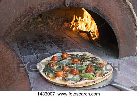 Fresh pizza on peel in traditional oven View Large Photo Image Stock Photo - Fresh pizza on peel in traditional oven. Fotosearch