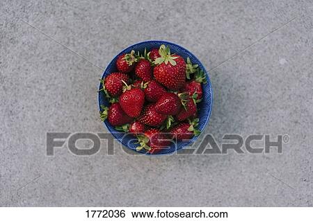 Stock Photograph - Fresh, ripe red strawberries in blue bowl. Fotosearch