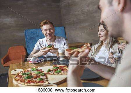 Friends enjoying pizza at restaurant View Large Photo Image Stock Photo - Friends enjoying pizza at restaurant. Fotosearch
