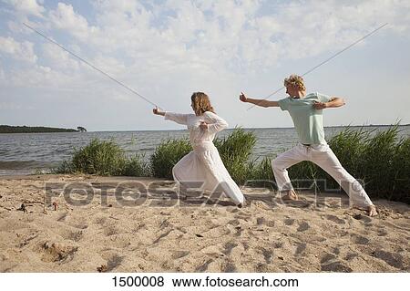Friends practicing yoga on sea shore at beach against sky View Large Photo Image Stock Photo - Friends practicing yoga on sea shore at beach against sky. Fotosearch