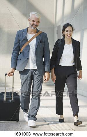 Full length of business colleagues walking with bag on airport View Large Photo Image Stock Image - Full length of business colleagues walking with bag on airport. Fotosearch