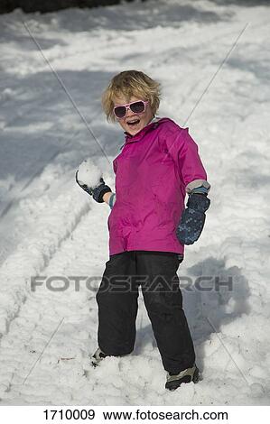 Stock Photo - Full length of cheerful boy holding snowball. Fotosearch