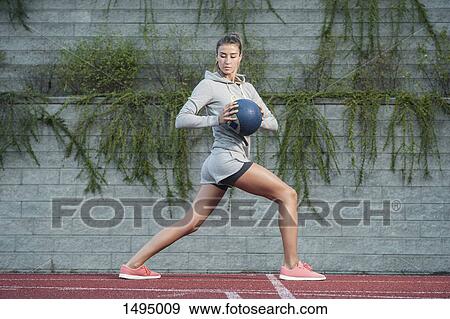 Full length of confident female athlete exercising with medicine ball View Large Photo Image Stock Photo - Full length of confident female athlete exercising with medicine ball. Fotosearch