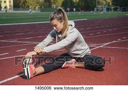 Full length of female athlete stretching on race track View Large Photo Image Stock Photograph - Full length of female athlete stretching on race track. Fotosearch