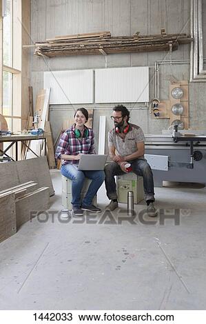 Full length of happy carpenters using laptop in workshop View Large Photo Image Stock Image - Full length of happy carpenters using laptop in workshop. Fotosearch