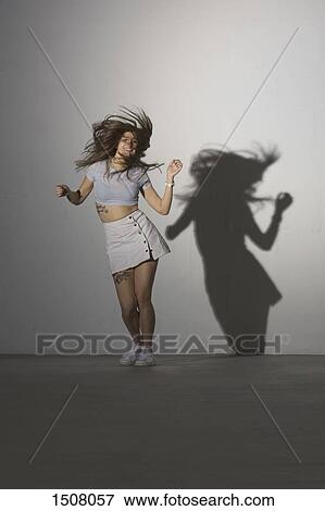 Full length of happy woman dancing against gray background View Large Photo Image Stock Photo - Full length of happy woman dancing against gray background. Fotosearch
