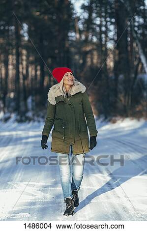Full length of happy woman walking on snow covered field View Large Photo Image Picture - Full length of happy woman walking on snow covered field. Fotosearch