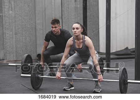 Full length of male and female athlete exercising with barbells during crossfit training View Large Photo Image Stock Photo - Full length of male and female athlete exercising with barbells during crossfit training. Fotosearch