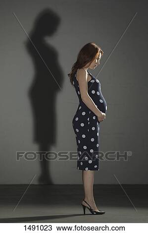 Full length of pregnant woman with shadow against gray background View Large Photo Image Stock Image - Full length of pregnant woman with shadow against gray background. Fotosearch