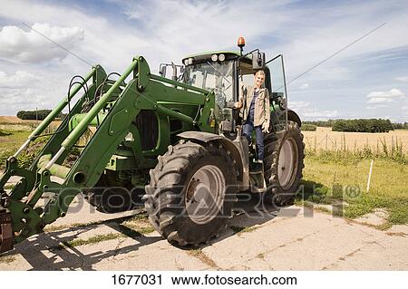 Full length of smiling mature woman standing on agricultural machinery against sky View Large Photo Image Stock Image - Full length of smiling mature woman standing on agricultural machinery against sky. Fotosearch
