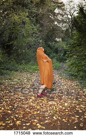 Full length of woman covered in orange scarf dancing at park during autumn View Large Photo Image Stock Photo - Full length of woman covered in orange scarf dancing at park during autumn. Fotosearch