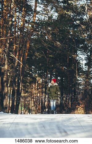 Full length of woman walking in snow covered forest View Large Photo Image Stock Photo - Full length of woman walking in snow covered forest. Fotosearch