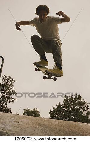 Full length of young man skateboarding at park against clear sky View Large Photo Image Stock Image - Full length of young man skateboarding at park against clear sky. Fotosearch