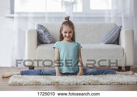 Full length portrait of smiling girl doing splits on rug in living room at home View Large Photo Image Stock Image - Full length portrait of smiling girl doing splits on rug in living room at home. Fotosearch