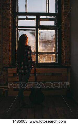 Full length rear view of woman with guitar standing by window at home View Large Photo Image Stock Image - Full length rear view of woman with guitar standing by window at home. Fotosearch