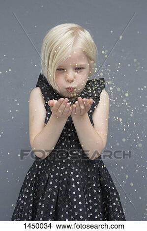 Girl blowing glitter against gray background View Large Photo Image Picture - Girl blowing glitter against gray background. Fotosearch