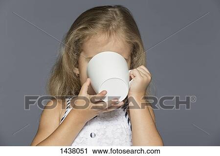 Girl drinking coffee against gray background View Large Photo Image Stock Image - Girl drinking coffee against gray background. Fotosearch