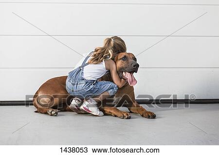 Stock Image - Girl embracing dog outdoors. Fotosearch