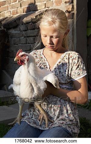 Stock Image - Girl holding rooster. Fotosearch