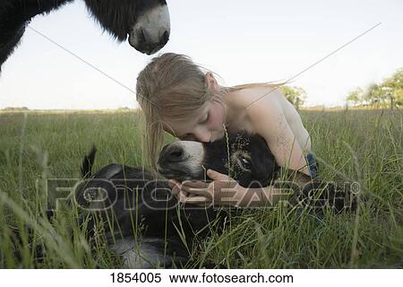 Girl hugging and kissing baby donkey in grass View Large Photo Image Stock Photography - Girl hugging and kissing baby donkey in grass. Fotosearch