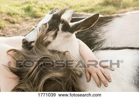 Girl hugging goat View Large Photo Image Stock Photo - Girl hugging goat. Fotosearch