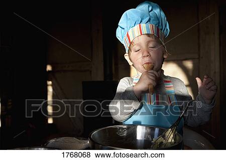 Stock Photo - Girl in chefs hat baking. Fotosearch