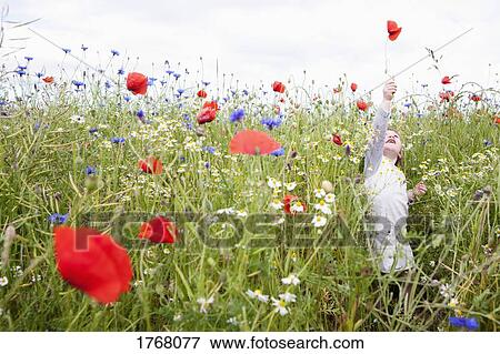 Stock Photo - Girl playing in field of wildflowers. Fotosearch