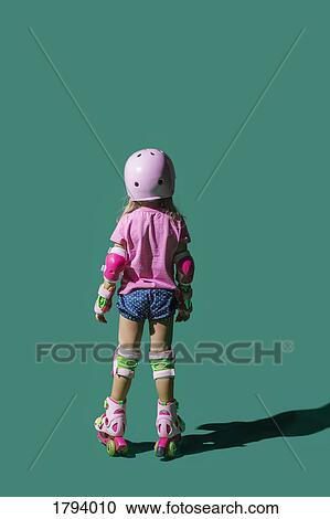 Girl roller skating on green background View Large Photo Image Stock Image - Girl roller skating on green background. Fotosearch