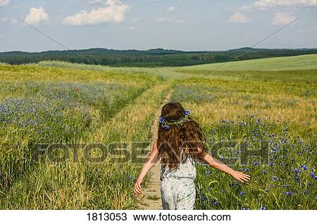 Girl running in sunny, rural idyllic green field with wildflowers View Large Photo Image Stock Image - Girl running in sunny, rural idyllic green field with wildflowers. Fotosearch