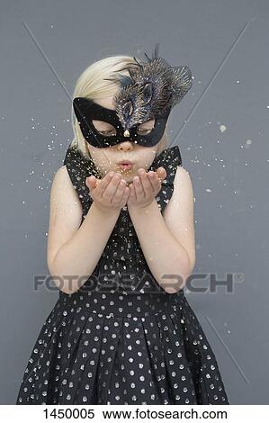 Girl wearing masquerade mask blowing glitters against gray background View Large Photo Image Stock Photography - Girl wearing masquerade mask blowing glitters against gray background. Fotosearch