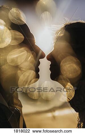 Golden light illuminating silhouetted profile of couple kissing View Large Photo Image Stock Image - Golden light illuminating silhouetted profile of couple kissing. Fotosearch