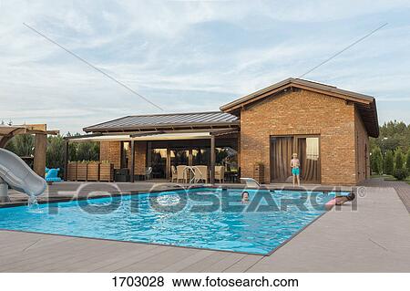 Grandmother and children enjoying weekend in swimming pool against sky View Large Photo Image Stock Photo - Grandmother and children enjoying weekend in swimming pool against sky. Fotosearch