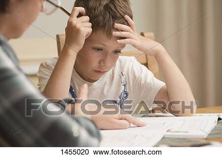 Stock Image - Grandmother explaining grandson on table at home. Fotosearch