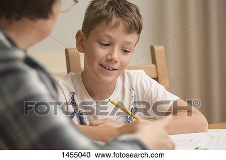 Grandmother teaching boy on table at home View Large Photo Image Stock Image - Grandmother teaching boy on table at home. Fotosearch
