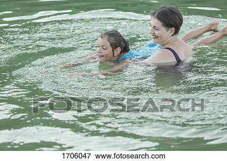 Grandmother teaching granddaughter in swimming pool View Large Photo Image Stock Photo - Grandmother teaching granddaughter in swimming pool. Fotosearch