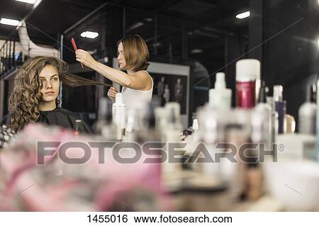 Hairdresser combing fashion model's hair View Large Photo Image Stock Photograph - Hairdresser combing fashion model's hair. Fotosearch