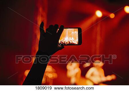 Hand in audience video recording musical concert with camera phone View Large Photo Image Stock Photo - Hand in audience video recording musical concert with camera phone. Fotosearch
