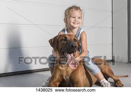 Happy cute girl looking away while sitting on dog outdoors View Large Photo Image Stock Photography - Happy cute girl looking away while sitting on dog outdoors. Fotosearch