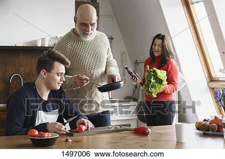 Happy family cooking food together at home View Large Photo Image Stock Photograph - Happy family cooking food together at home. Fotosearch