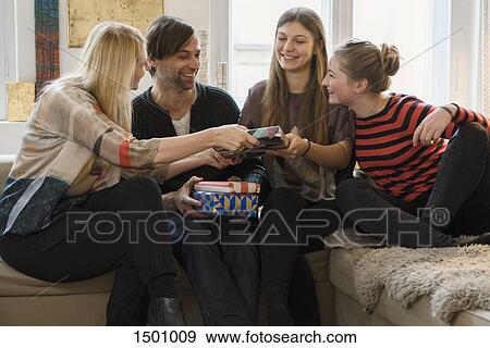 Stock Photo - Happy family giving presents to daughter in living room. Fotosearch
