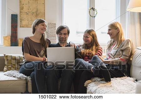 Happy family with father using laptop in living room View Large Photo Image Stock Image - Happy family with father using laptop in living room. Fotosearch