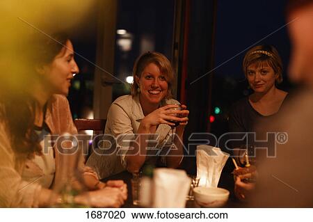 Stock Image - Happy female friends enjoying birthday party at home. Fotosearch