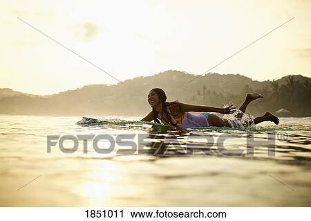 Happy female surfer paddling out in ocean on surfboard, Sayulita, Nayarit, Mexico View Large Photo Image Stock Image - Happy female surfer paddling out in ocean on surfboard, Sayulita, Nayarit, Mexico. Fotosearch
