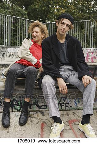 Happy friends sitting on steps at park View Large Photo Image Stock Photo - Happy friends sitting on steps at park. Fotosearch