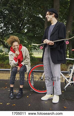 Happy friends with bicycle and skateboard at park View Large Photo Image Stock Image - Happy friends with bicycle and skateboard at park. Fotosearch