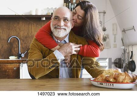 Happy mature couple embracing at home View Large Photo Image Stock Image - Happy mature couple embracing at home. Fotosearch