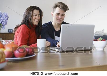 Happy mother and son using laptop on table at home View Large Photo Image Stock Image - Happy mother and son using laptop on table at home. Fotosearch