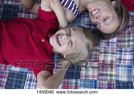 Happy mother looking son while relaxing in backyard View Large Photo Image Stock Photograph - Happy mother looking son while relaxing in backyard. Fotosearch