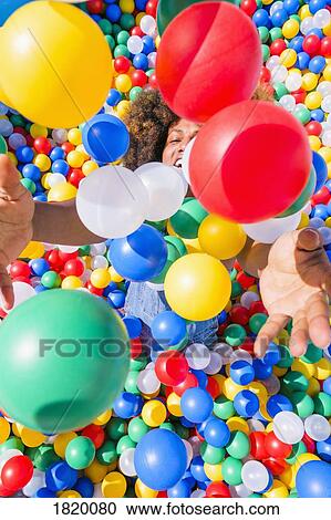 Happy young man playing in vibrant ball pool View Large Photo Image Stock Image - Happy young man playing in vibrant ball pool. Fotosearch