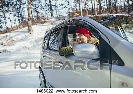 Happy young woman in car during winter View Large Photo Image Stock Image - Happy young woman in car during winter. Fotosearch